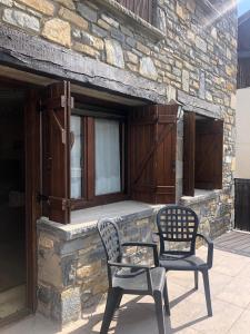 - une terrasse avec 2 chaises et une table dans l'établissement Los Llanos de Escarrilla, à Escarrilla