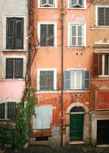 een oud gebouw met een groene deur en ramen bij Roma center Fori Imperiali Raffy's charming Suite in Rome