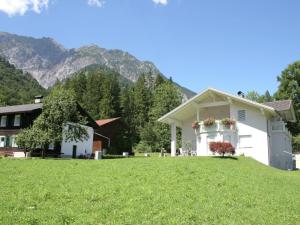 a house on a grassy hill with mountains in the background at Holiday home near the ski area in Vandans in Vandans