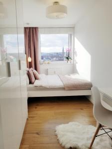 Apartament LENA OLD TOWN with a UNIQUE VIEW في غدانسك: غرفة نوم بيضاء بها سرير ونافذة