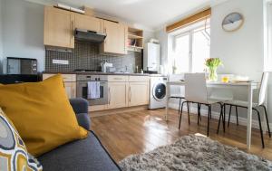 a kitchen and living room with a couch and a table at Ideal Lodgings in Bury - Fairfield in Bury