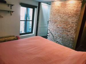 a bedroom with a brick wall and a bed at De Pastorie in Middelburg