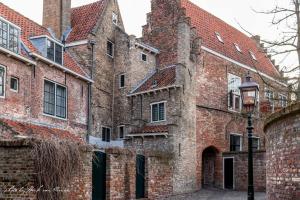 an old brick building with a street light in front of it at De Pastorie in Middelburg