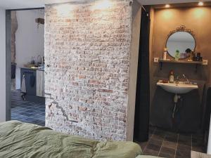 a bathroom with a brick wall and a sink at De Pastorie in Middelburg