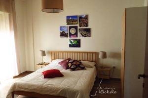 a bedroom with a bed with pillows and pictures on the wall at La Stanza di Rachele in Naples