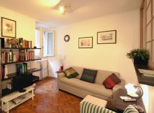 Roma center Fori Imperiali Raffy's charming Suite في روما: غرفة معيشة مع أريكة ورف كتاب