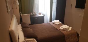 a small room with a bed with towels on it at Mia Suites in Rome