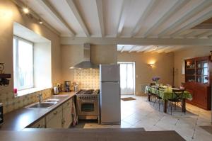 a kitchen with a sink and a stove top oven at Le cottage de Savigny in Valognes