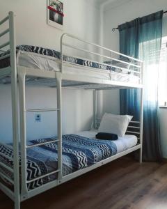 a bedroom with two bunk beds in a room at Pirata hostel Milfontes in Vila Nova de Milfontes