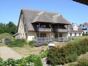a large house with a thatched roof at Fewos Herrmann Achterwasserblick in Loddin