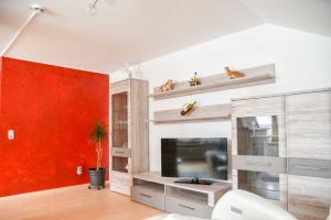 sala de estar con TV y pared roja en Landgasthof Benjamin en Treffelstein