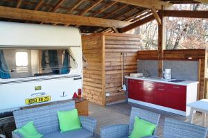an outdoor kitchen with an rv and a table and chairs at Camping du Moulin de Thoard in Thoard