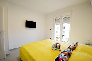 a bedroom with a yellow bed and a television at La Piazza in Umag