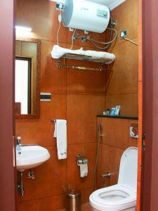a bathroom with a toilet and a sink at Staylite Suites in Chennai