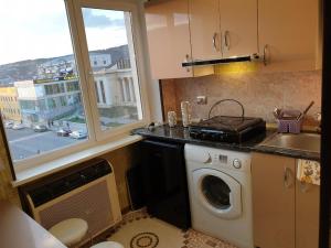una cucina con lavatrice e finestra di Сергей Сергеевич a Akhaltsikhe