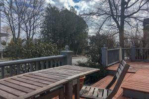 a wooden bench on a deck with a fence at 36 Main Apartments in Castine