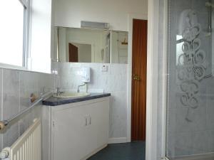 a bathroom with a sink and a mirror and a shower at Beeton Villas Holiday Apartments in Blackpool +84 photos