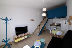 a living room with a staircase and a dining room at Sous Les Pins gîtes et chambres d'hôtes in La Londe-les-Maures