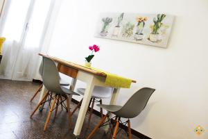 カリアリにあるSa Domu de Ajaja Apartmentsの椅子付テーブル、花瓶付の壁