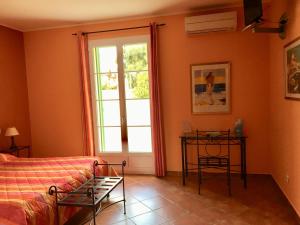 1 dormitorio con cama y ventana en Hotel Du Vignoble, en Patrimonio