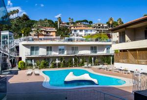 a large swimming pool in front of a building at Ciclope Resort in Acitrezza
