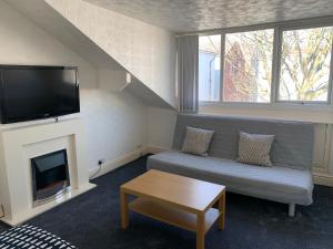 a living room with a couch and a flat screen tv at Beeton Villas Holiday Apartments in Blackpool