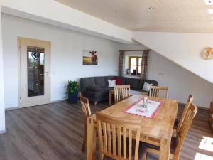 a dining room and living room with a table and chairs at Ferienwohnung Linder in Hopferau