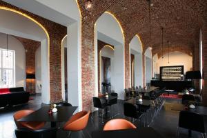 a restaurant with black tables and orange chairs at Hotel The Lodge Vilvoorde in Vilvoorde