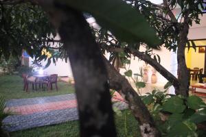 a backyard with a table and chairs and a tree at Miheen Hotel & Resort - Anuradhapura in Mihintale