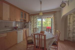 a kitchen with a table and chairs and a window at Вила Теkето I Vila Teketo Family Guest House in Nikolovo