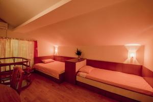 1 dormitorio con 2 camas, mesa y silla en Къща за гости Вила Теkето I Family Guest House Villa Teketo en Nikolovo