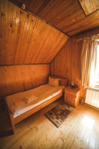 a bedroom with a bed in a wooden room at Karpatski Polonyny in Urych