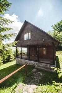 a log cabin with a porch and a fence at Karpatski Polonyny in Urych