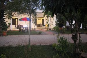 a patio with a table and a red and blue umbrella at Miheen Hotel & Resort - Anuradhapura in Mihintale