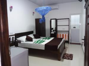 a bedroom with a bed with a blue balloon on it at Theepan's Home in Nilaveli