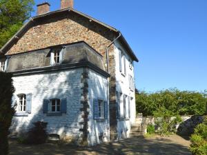 un ancien bâtiment en pierre avec des fenêtres et un toit dans l'établissement Quiet cottage in Roumont, à Roumont