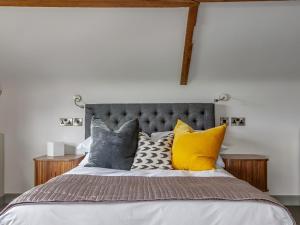 a bedroom with a bed with yellow and grey pillows at The Ingham Swan in Stalham
