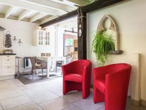 eine Küche und ein Esszimmer mit roten Stühlen und einem Tisch in der Unterkunft This accommodation is full of atmosphere and on a beautiful estate in Zedelgem