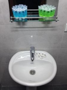 a white sink in a bathroom with drinking glasses at Hotel Continental in Gori