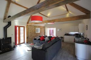 a living room with a couch and a kitchen at Flintstone Cottages in Chichester