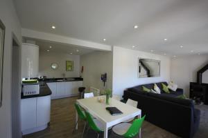a living room and kitchen with a table and a couch at Flintstone Cottages in Chichester