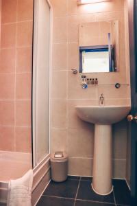 a small bathroom with a sink and a shower at New Town Guest House (Adults Only) in Edinburgh