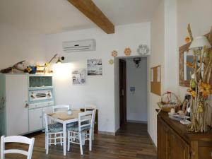 a kitchen and dining room with a table and chairs at B&B LE ISOLE in San Teodoro