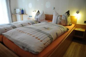 a bedroom with two beds with white blankets and pillows at Gästehaus Petra in Ürzig