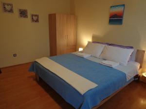 a bedroom with a large bed with blue and white sheets at Guesthouse Aotearoa Premantura in Premantura