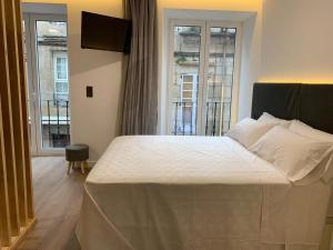 a bedroom with a bed and a large window at Galerías 16 Viviendas Turísticas in Lugo