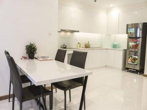 cocina con mesa blanca, sillas y nevera en Capitalland's Service Apartment Landmark 1 Vinhomes en Ho Chi Minh
