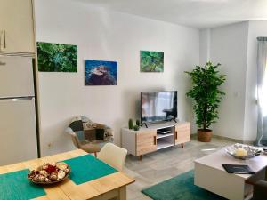 een woonkamer met een televisie en een tafel bij Luxury Doña Carlota in Torremolinos