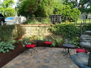 a patio with red chairs and tables and a wall at Lamberson Guest House in Galena