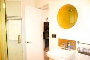 a bathroom with a sink and a mirror on the wall at Ocean Front Vortex Female Hostel private rooms Free bikes in Los Angeles +27 photos